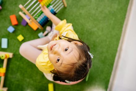 Girl in Yellow Dress Looking Up While Playing