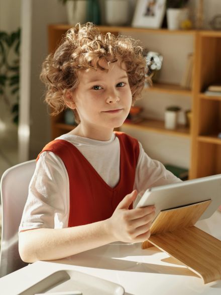 Girl in White and Red Crew Neck T-shirt Using Tablet