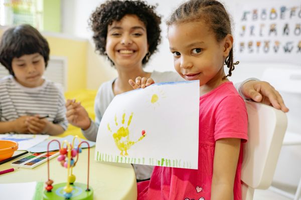 Girl in Pink Dress Holding White Paper With Painting Of Her Hand